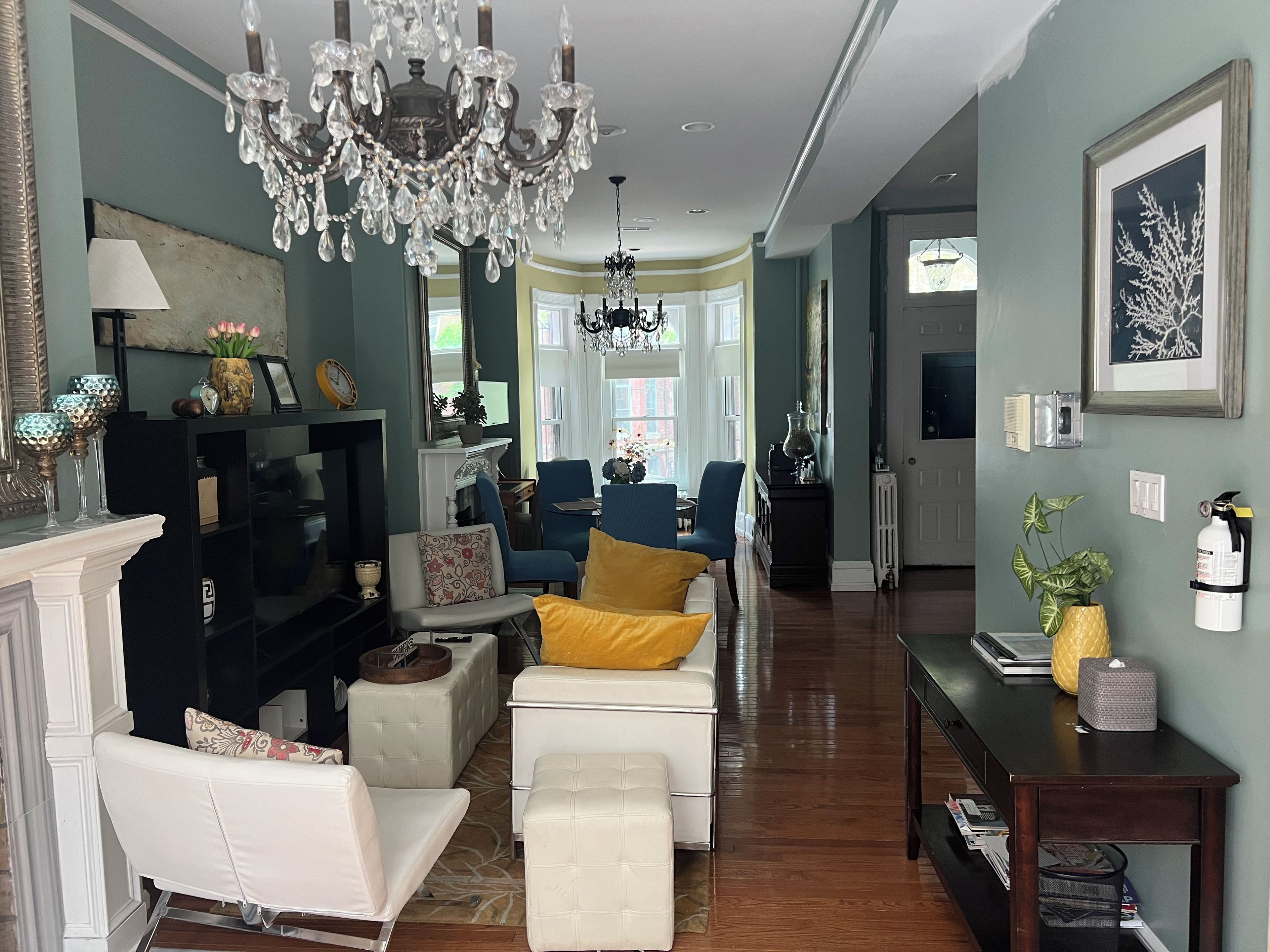 A spacious living room with a fireplace, seating area, and a chandelier.