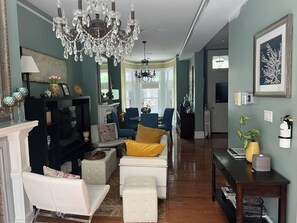 Ein geräumiges Wohnzimmer mit Kamin, Sitzecke und einer Chandelier.