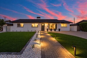 A modern two-story house with a well-maintained lawn, a paved driveway, and a clear sky. - NEW| The Tipsy Cactus Old Town Oasis|Pool+Bar+Putt (Scottsdale)