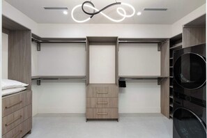 A modern closet with wooden drawers, a hanging rod, and a built-in shelf. - Mariposa Social Luxe Old Town Villa (Scottsdale)