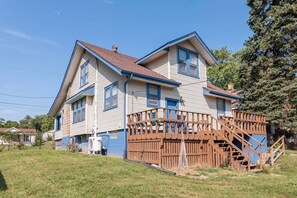A two-story house with a wooden deck and a staircase leading to a second-story balcony. - Sciota Suite | Private Entrance & Workspace (Peoria Heights)