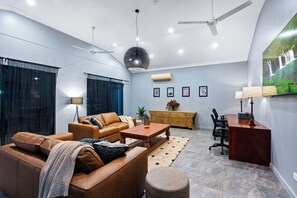 Una sala de estar moderna con sofá, mesa de centro y un comedor con sillas y una mesa.