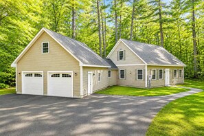 A two-story house with a garage, a covered porch, and a well-maintained lawn. - Cranmore & Story Land Hot Tub + Sauna Sleeps 10 (Conway)