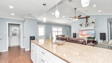 A spacious kitchen with a granite countertop, a built-in oven, and a ceiling fan.