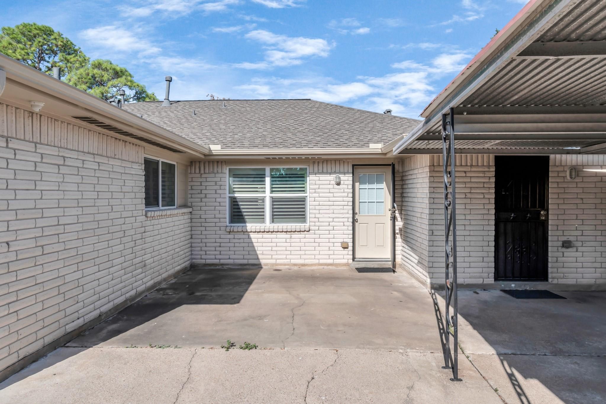 Un immeuble résidentiel doté d’un garage, d’une seule porte d’entrée et d’un petit jardin à l’avant.
