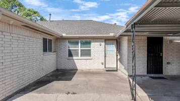 Un immeuble résidentiel doté d’un garage, d’une seule porte d’entrée et d’un petit jardin à l’avant.