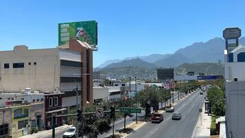 Una calle con edificios, un cartel publicitario y un cielo despejado.