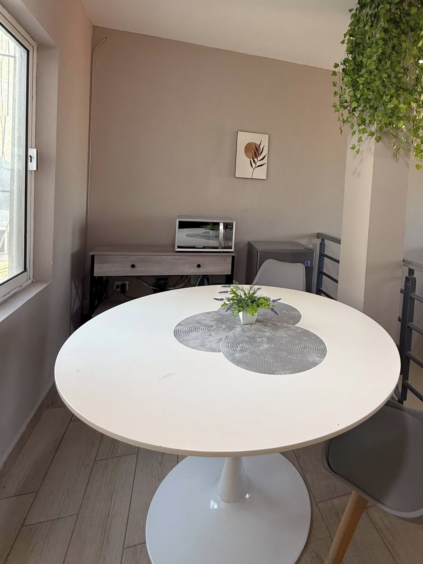 A round dining table with a white top and a central decorative item.