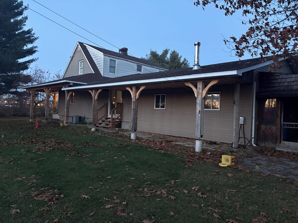A two-story house with a covered porch and a chimney.
