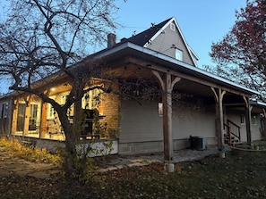 A house with a covered porch, a brick chimney, and a visible window.
