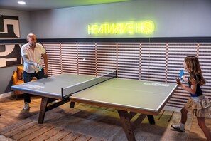 A ping pong table with a neon sign reading 'HEATWAVE HQ' in the background. - Heatwave HQ-Sport Court, Gym, Pool/SPA, Speakeasy (Scottsdale)