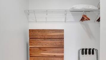 A room with a wooden bench, a metal rack, and a white wall.