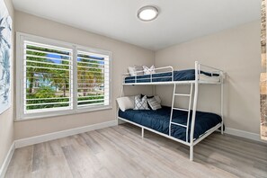 A room with a bunk bed, a window with blinds, and a light fixture on the ceiling. - Coastal Paradise | Waterfront, Heated Pool, Hot Tub & Dock Near Bonita Beach (Bonita Springs)