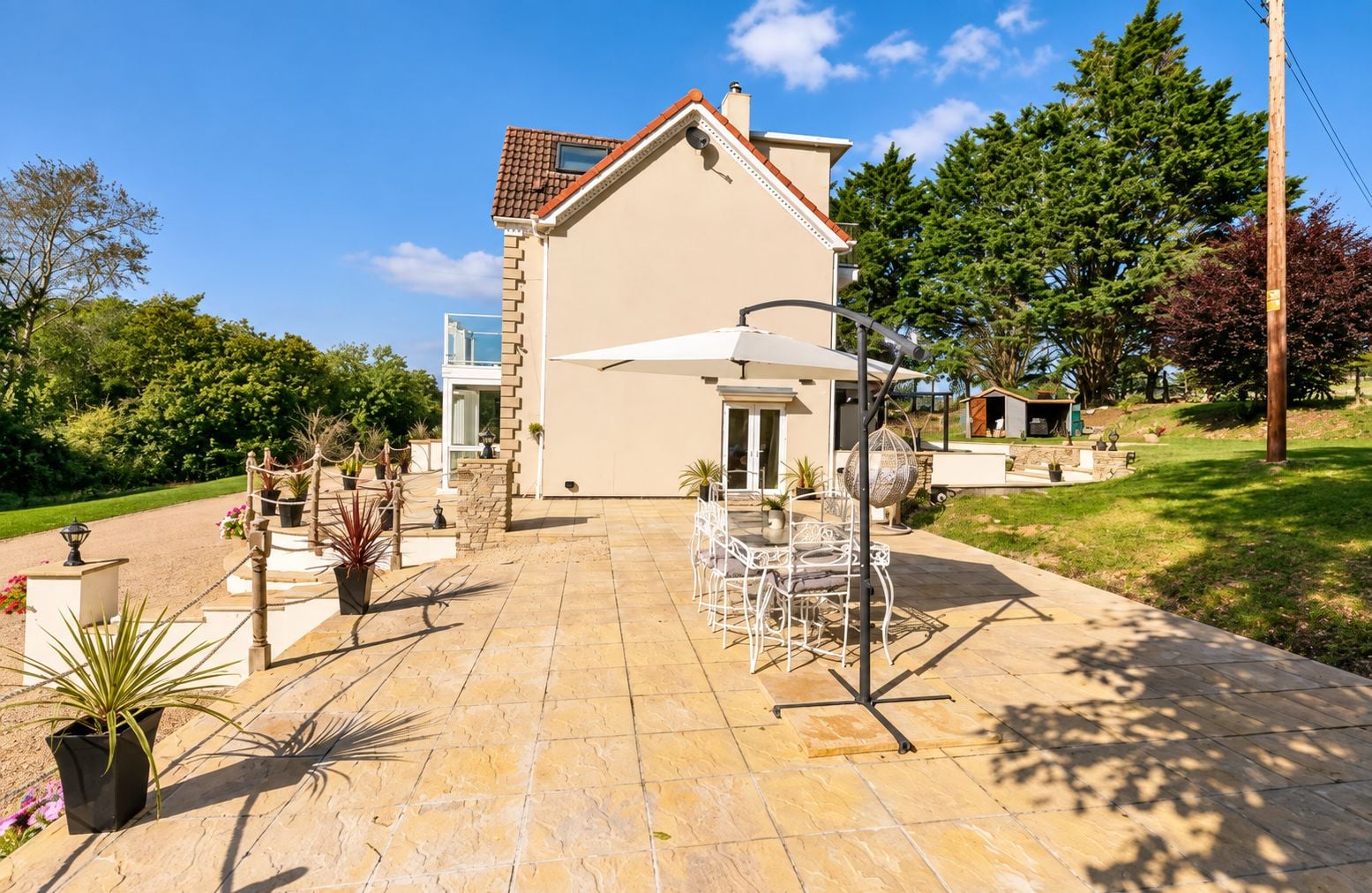 A house with a patio, outdoor furniture, and a garden.