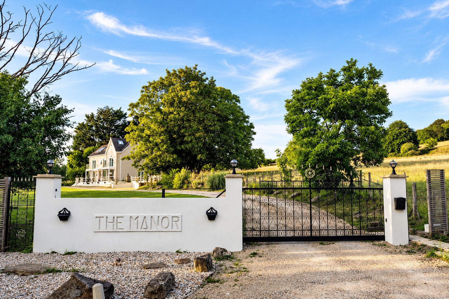 Ein begrenzter Zugang zu einem Anwesen namens 'The Manor', mit einer weißen Mauer und einem schwarzen Tor.