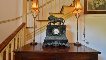A staircase with a clock and two lamps on a wooden table.