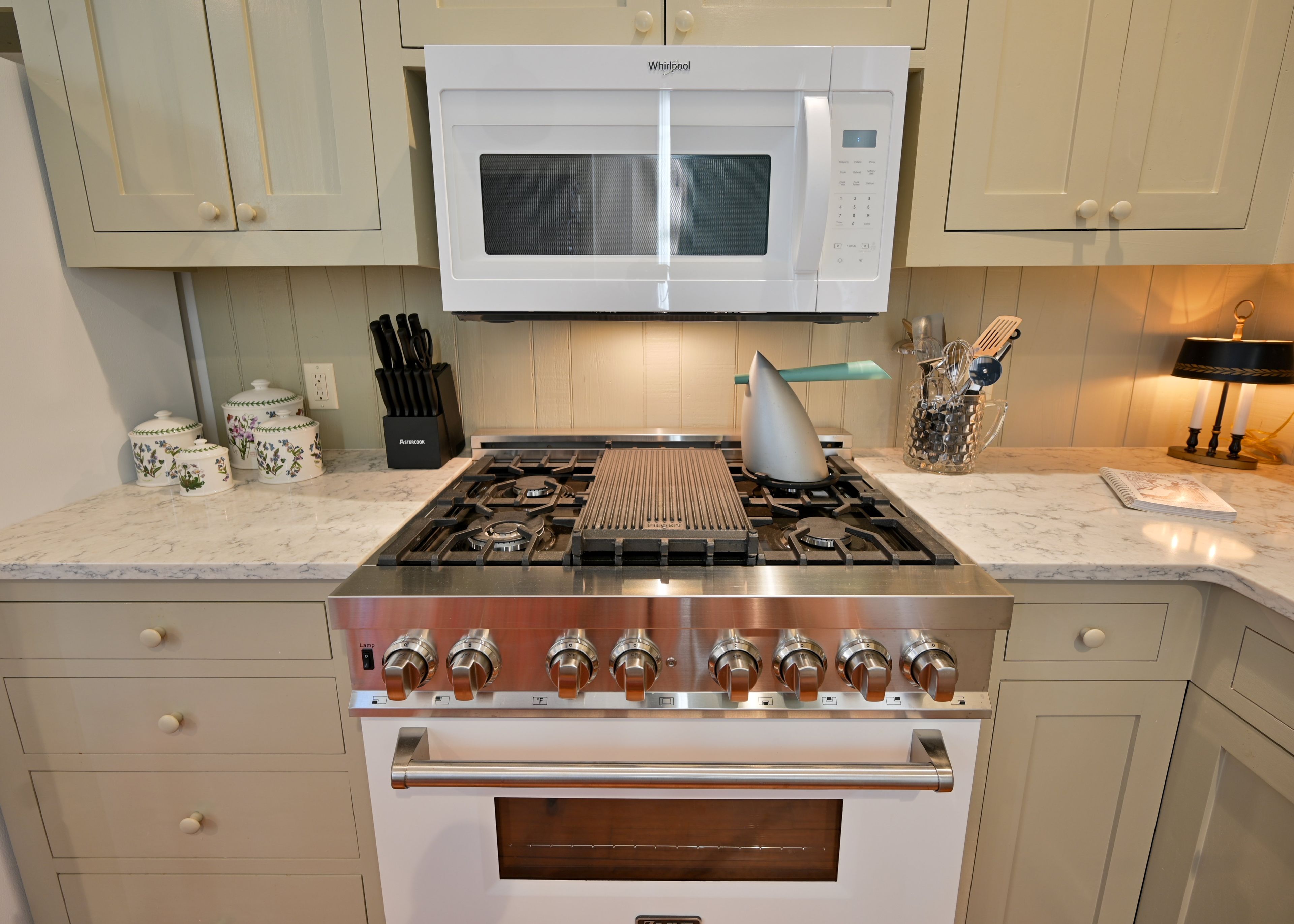 A kitchen with a white microwave, stainless steel stove, and oven.