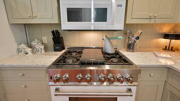 A kitchen with a white microwave, stainless steel stove, and oven.