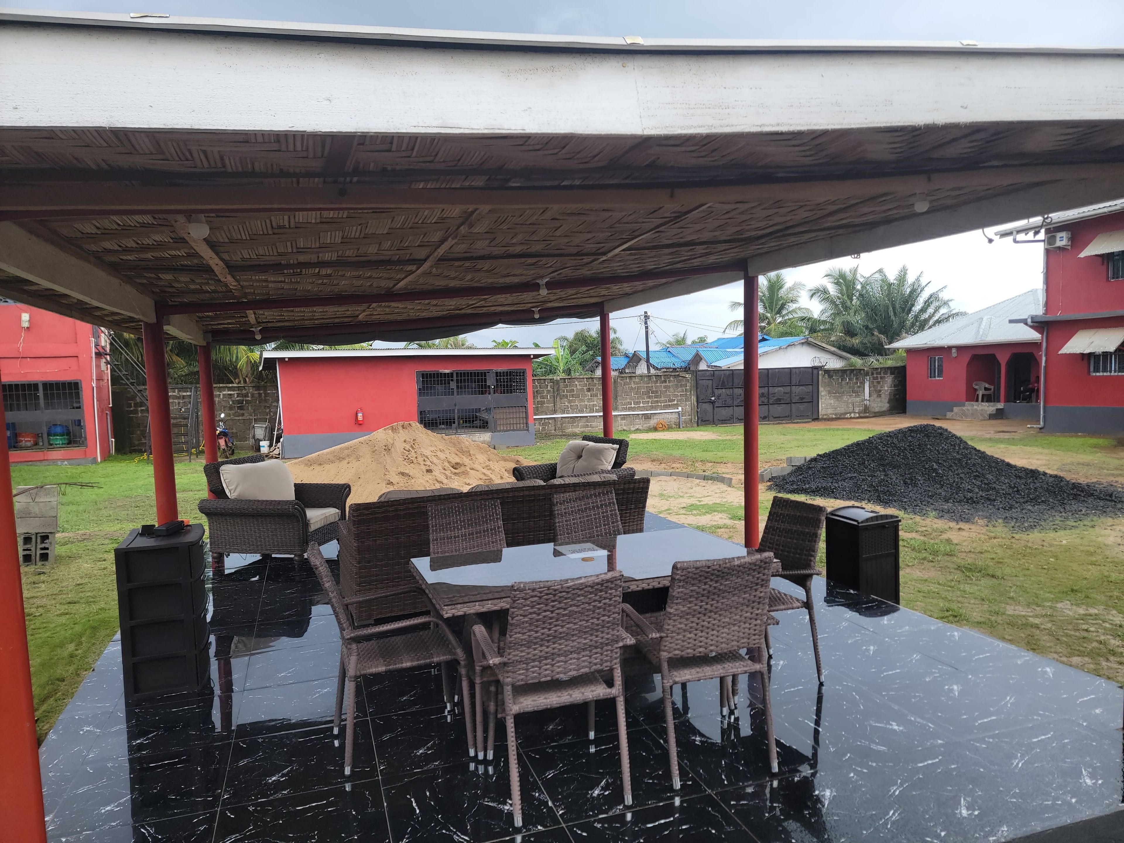 Un área de patio al aire libre con un espacio de estar techado y una mesa.