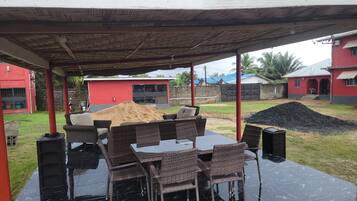 Un área de patio al aire libre con un espacio de estar techado y una mesa.