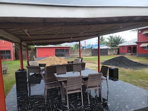 Un área de patio al aire libre con un espacio de estar techado y una mesa.