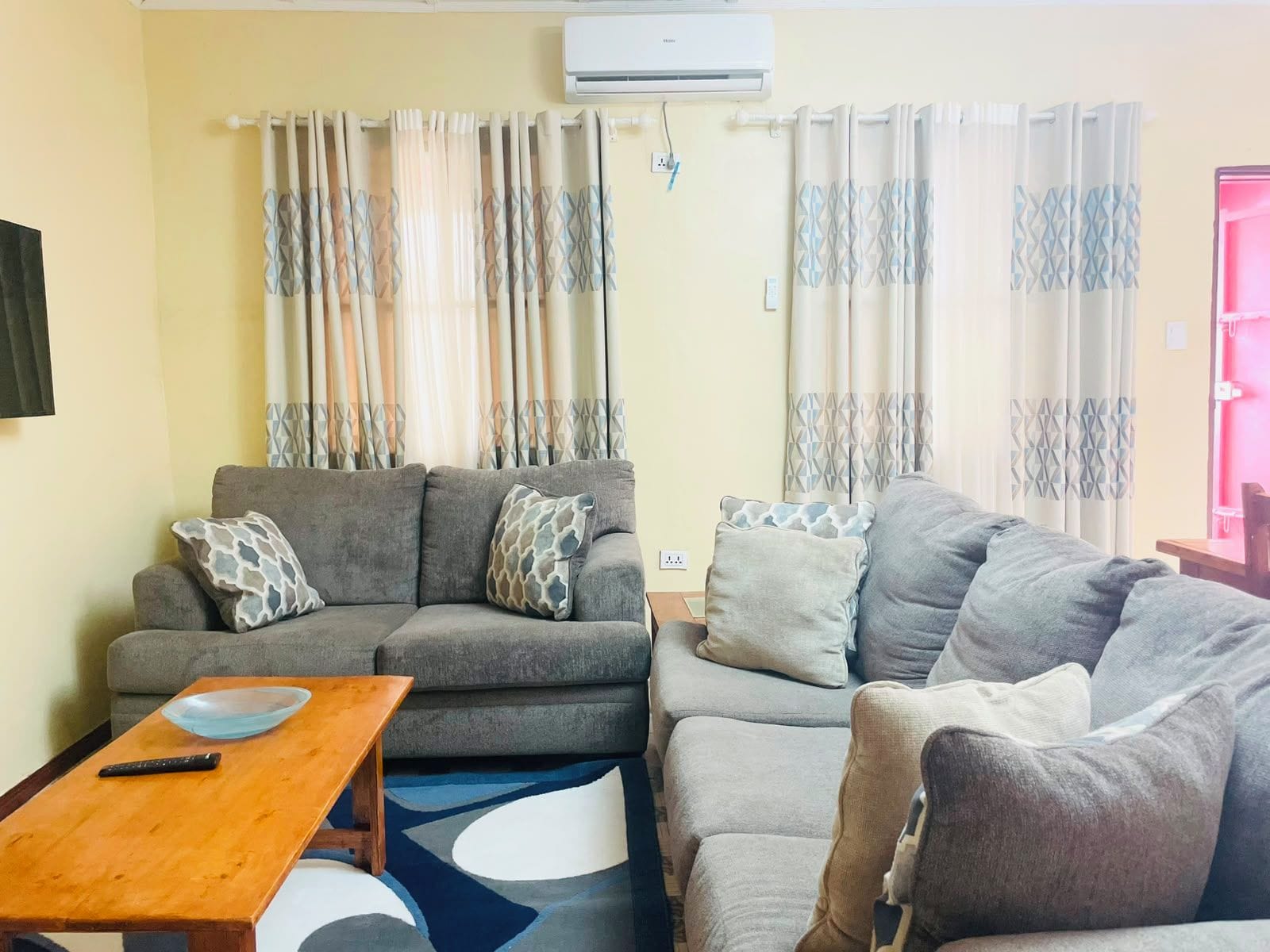 Una sala de estar con dos sofás, una mesa de centro y un televisor.