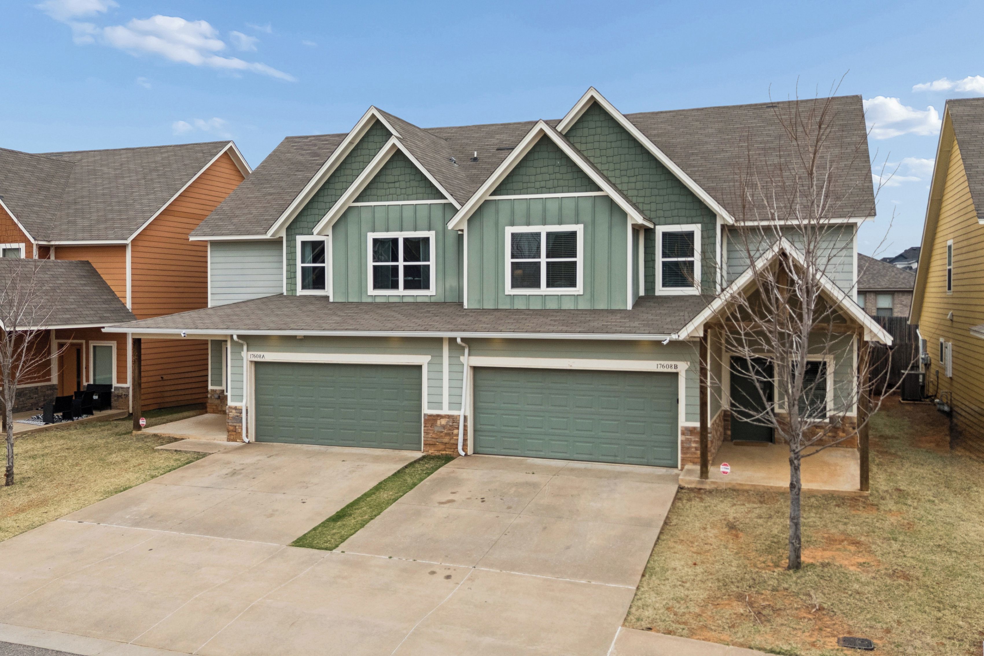 A two-story residential house with a garage, a front yard, and a driveway.