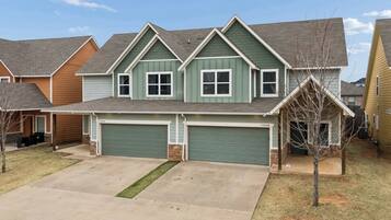A two-story residential house with a garage, a front yard, and a driveway.
