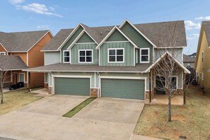 A two-story residential house with a garage, a front yard, and a driveway. - Spacious 5-bedroom house perfect for groups (Edmond)