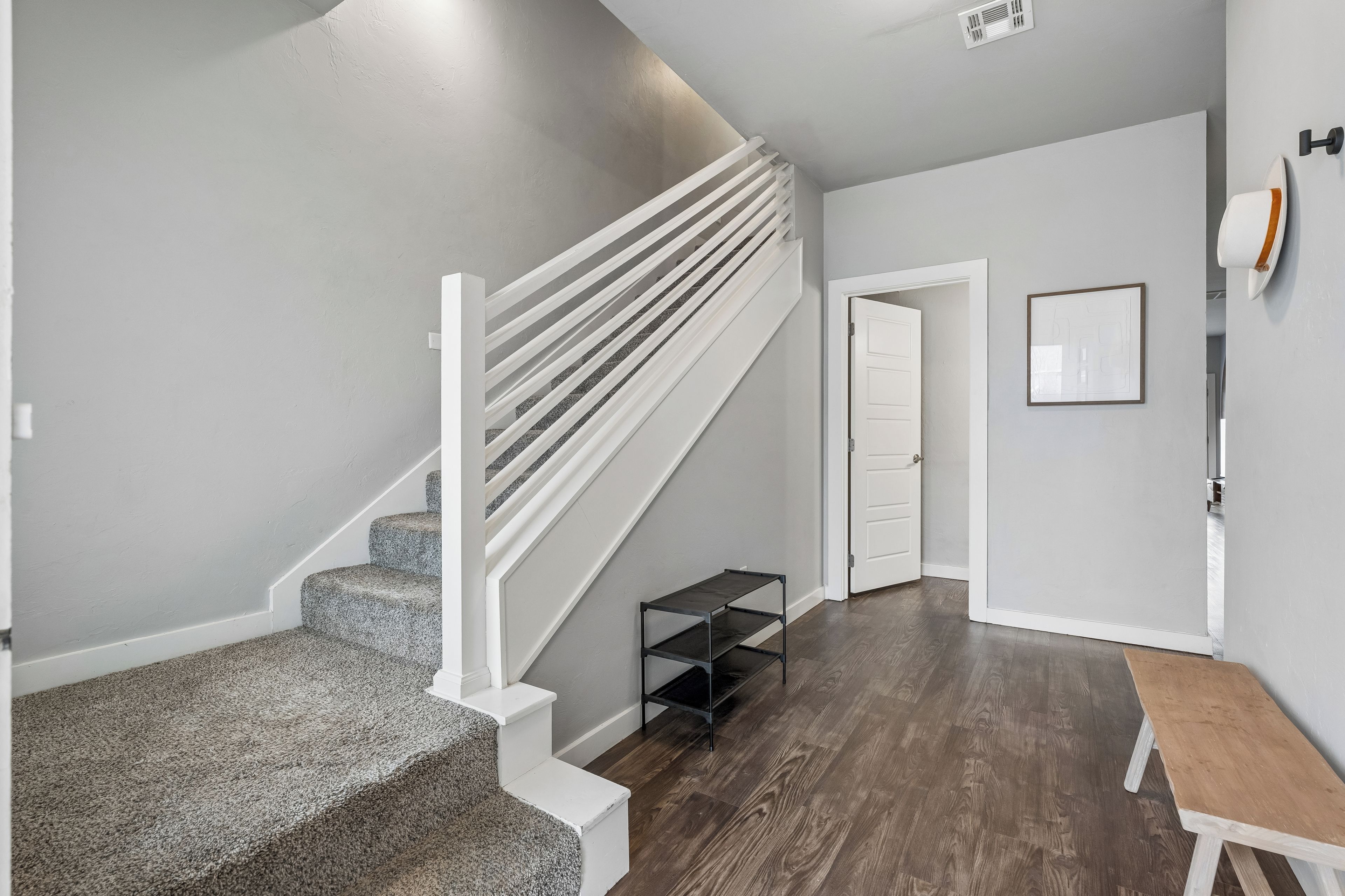 A staircase with white railings and carpeted steps leading to a landing.