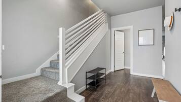 A staircase with white railings and carpeted steps leading to a landing.