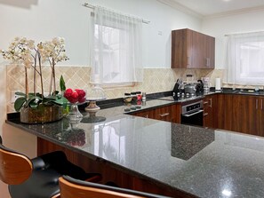 Eine moderne Küche mit Granit Arbeitsplatte, Holzschränken und einem eingebauten Backofen.