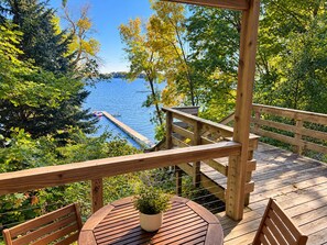 A wooden deck with a view of a lake, surrounded by trees. - French Lake Shores-Sunset Retreat/Private 3 Bedroom Lakefront for 8 (Faribault)