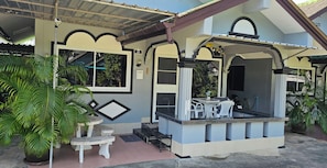 A two-story building with a balcony, outdoor seating, and potted plants. - Karon Homes (Karon)