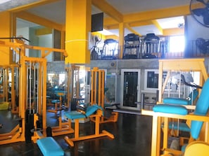 A gym with various exercise equipment, including weight machines and benches. - Karon Homes (Karon)