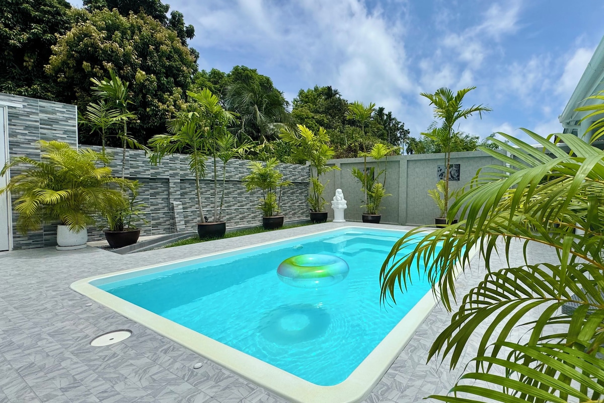 Una piscina rectangular amb superfície d'aigua blava cristal·lina, envoltada d'un solàrium amb rajoles.