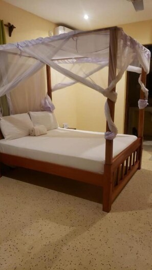 A four-poster bed with a canopy, wooden frame, and white bedding. - Bella Breeze1 - Diani Beach, Kenya (Diani Beach)