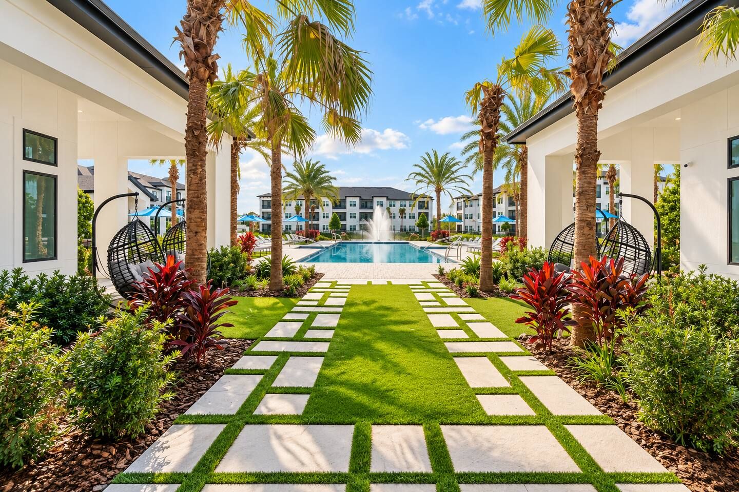 A pool area with a clear view of the pool, surrounded by palm trees and a well-maintained lawn.