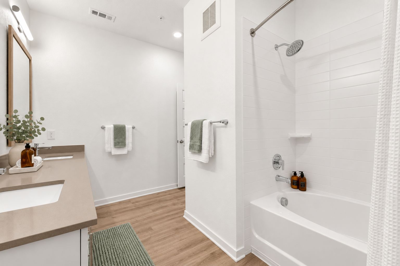 A modern bathroom with a shower, a sink, and a mirror.