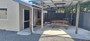 An outdoor patio area with a picnic table and a pergola structure.