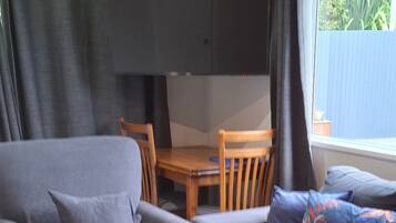A modern living room with a grey sofa, a wooden coffee table, and a television mounted on the wall.