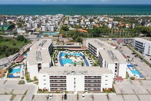 A hotel with a rooftop pool, multiple parking levels, and a view of the ocean.