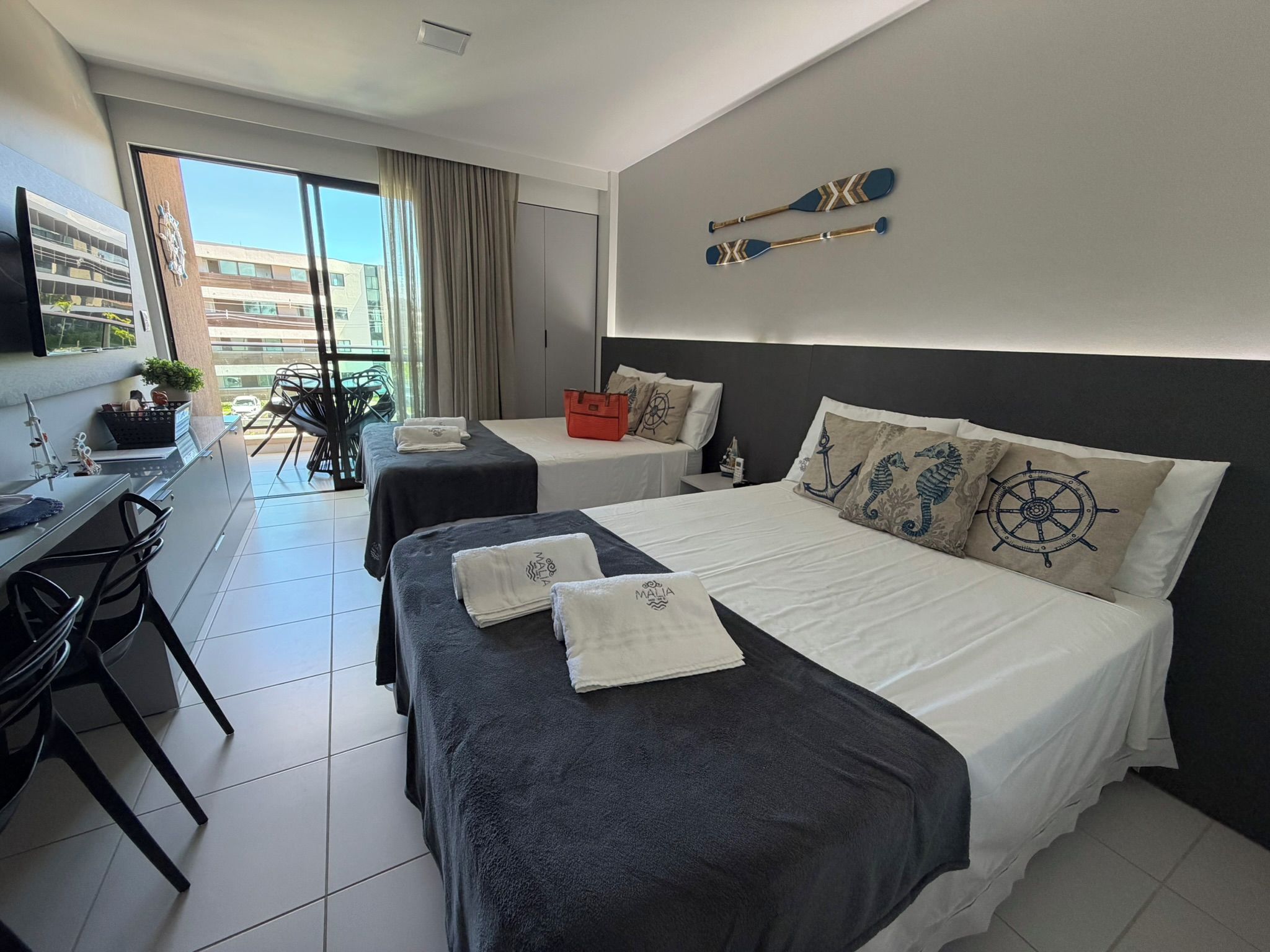 Una habitación de hotel con dos camas, un escritorio y una silla.