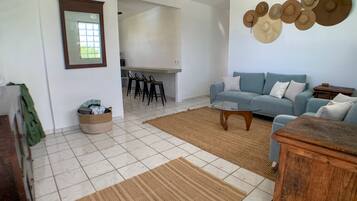 Un salón con sofá, mesa de centro y un perchero de pared.