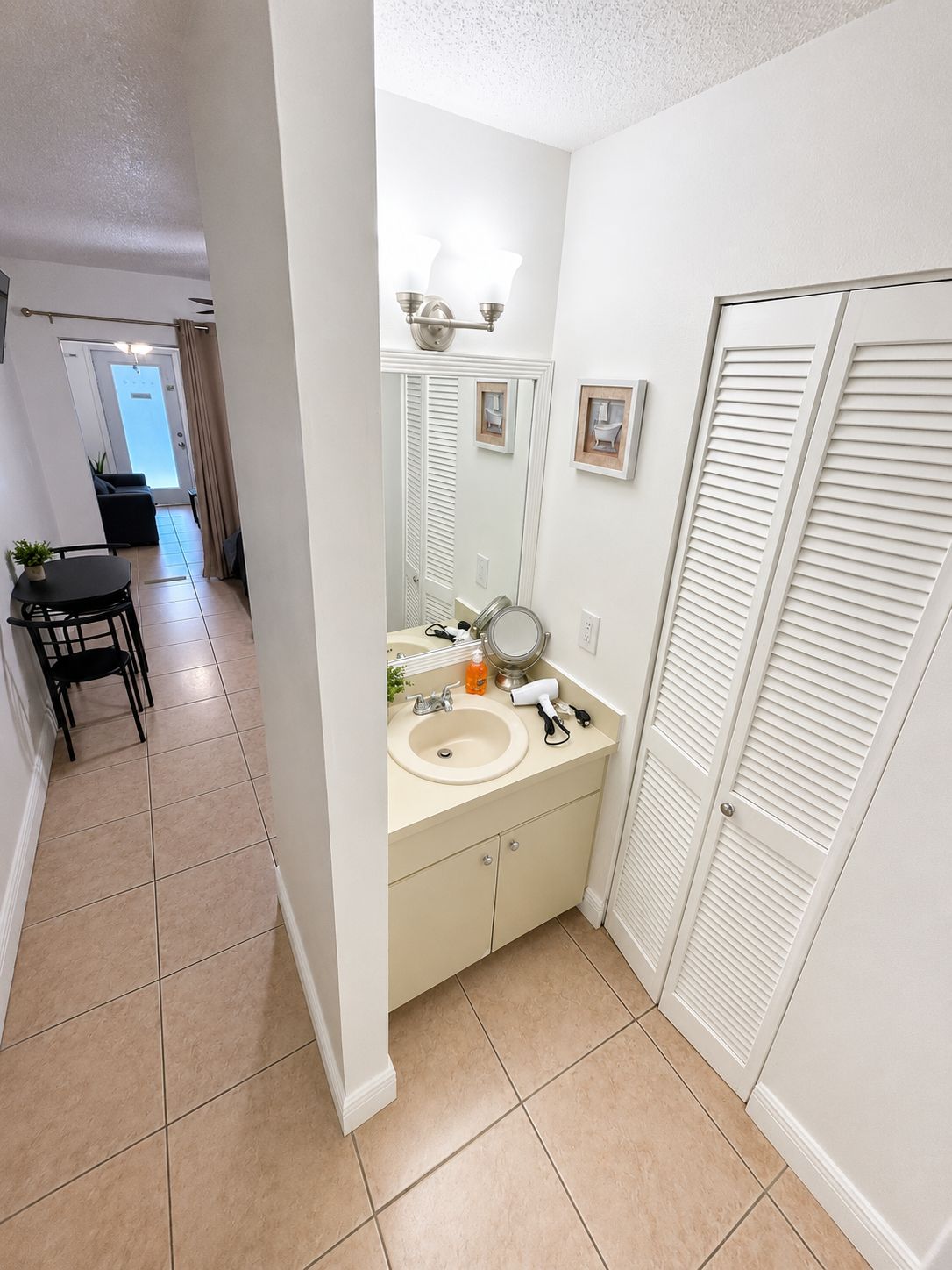 A bathroom with a sink, mirror, and towel rack.