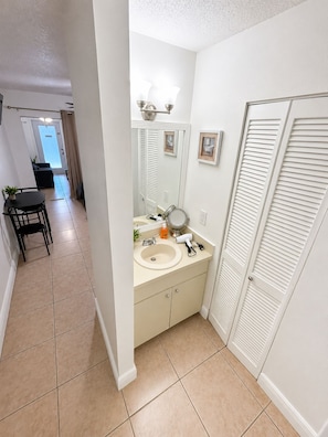 A bathroom with a sink, mirror, and towel rack.