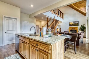A spacious kitchen with a large island, wooden cabinets, and a built-in dishwasher. - Close to Pkwy~Htd Pool~View~Hot Tub~Arcade~Fam Fav (Sevierville)