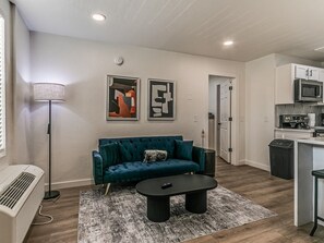 Un salon avec un canapé, une table basse et des œuvres d’art accrochées au mur.