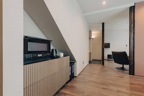 A modern interior with a kitchen area featuring a microwave, coffee maker, and cabinets. - Maru  (Shimotakai-gun)