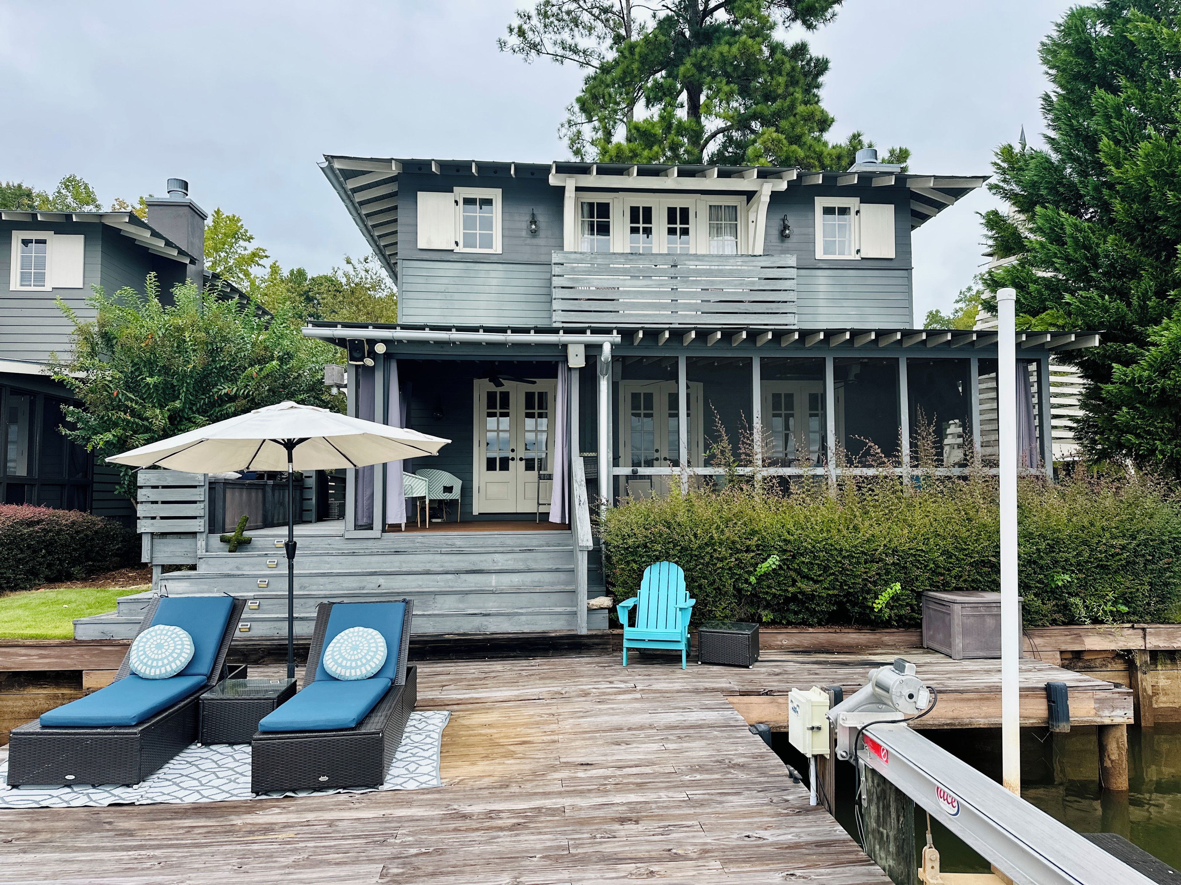 Een twee verdiepingen tellend huis met een overdekte veranda en een houten terras.
